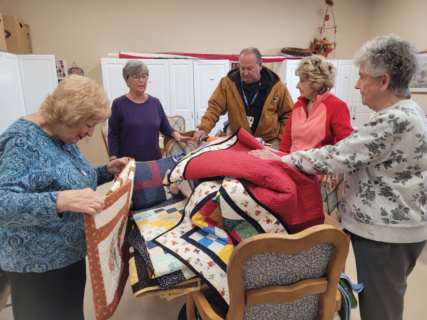 FROM THE FOLD: From left to right, Marie Lanzi, Fran Zanni, John Reis, Betty Bryda and Evelyn Cedroni fold quilts they donated to Children’s Friend and Services, for families in need.